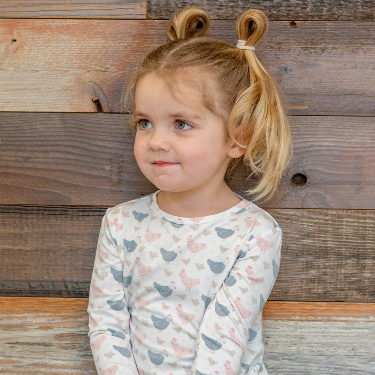 Kids bamboo pajama set with white base and blue/pink farm hen print, long-sleeve top