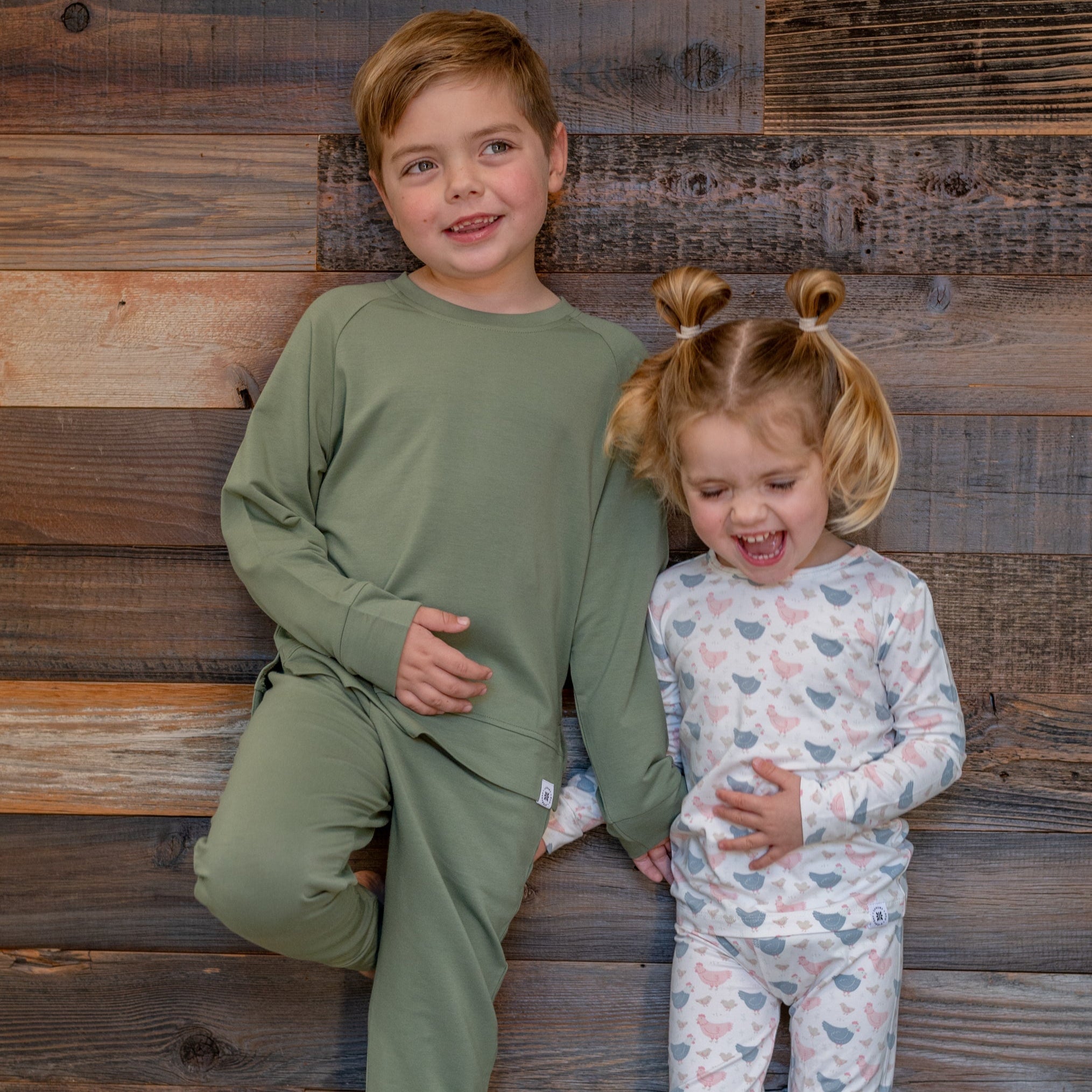 Kids bamboo pajama set with white base and blue/pink farm hen print, long-sleeve top and pants