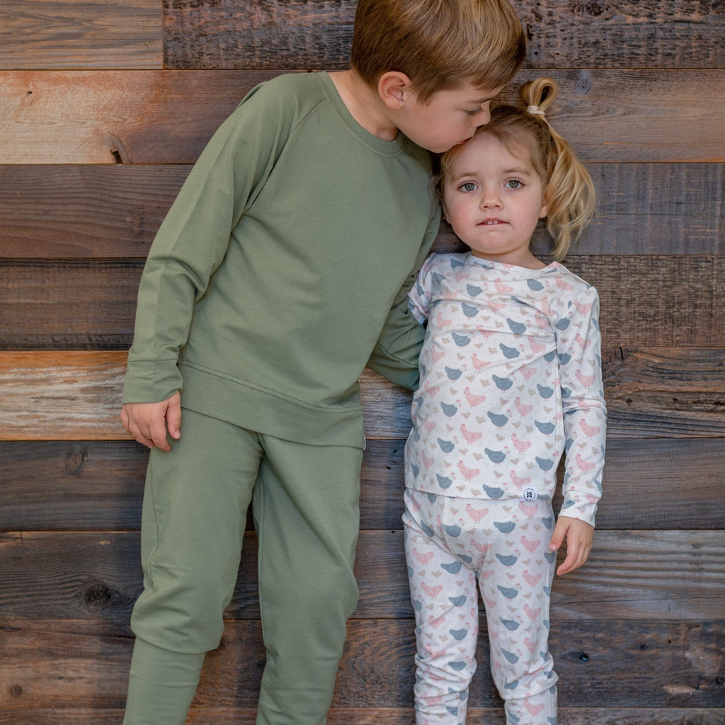 Kids bamboo pajama set with white base and blue/pink farm hen print, long-sleeve top