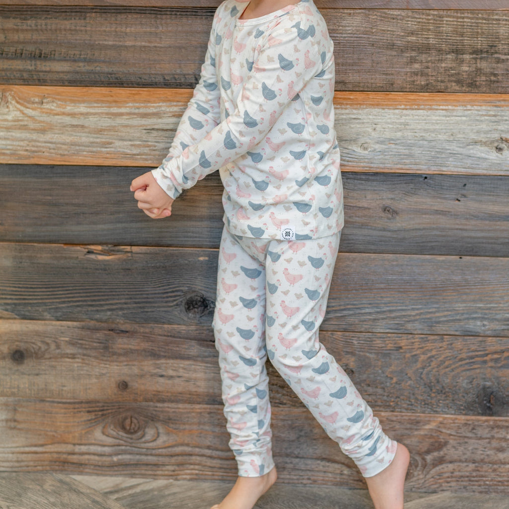 Kids bamboo pajama set with white base and blue/pink farm hen print, long sleeves and pants