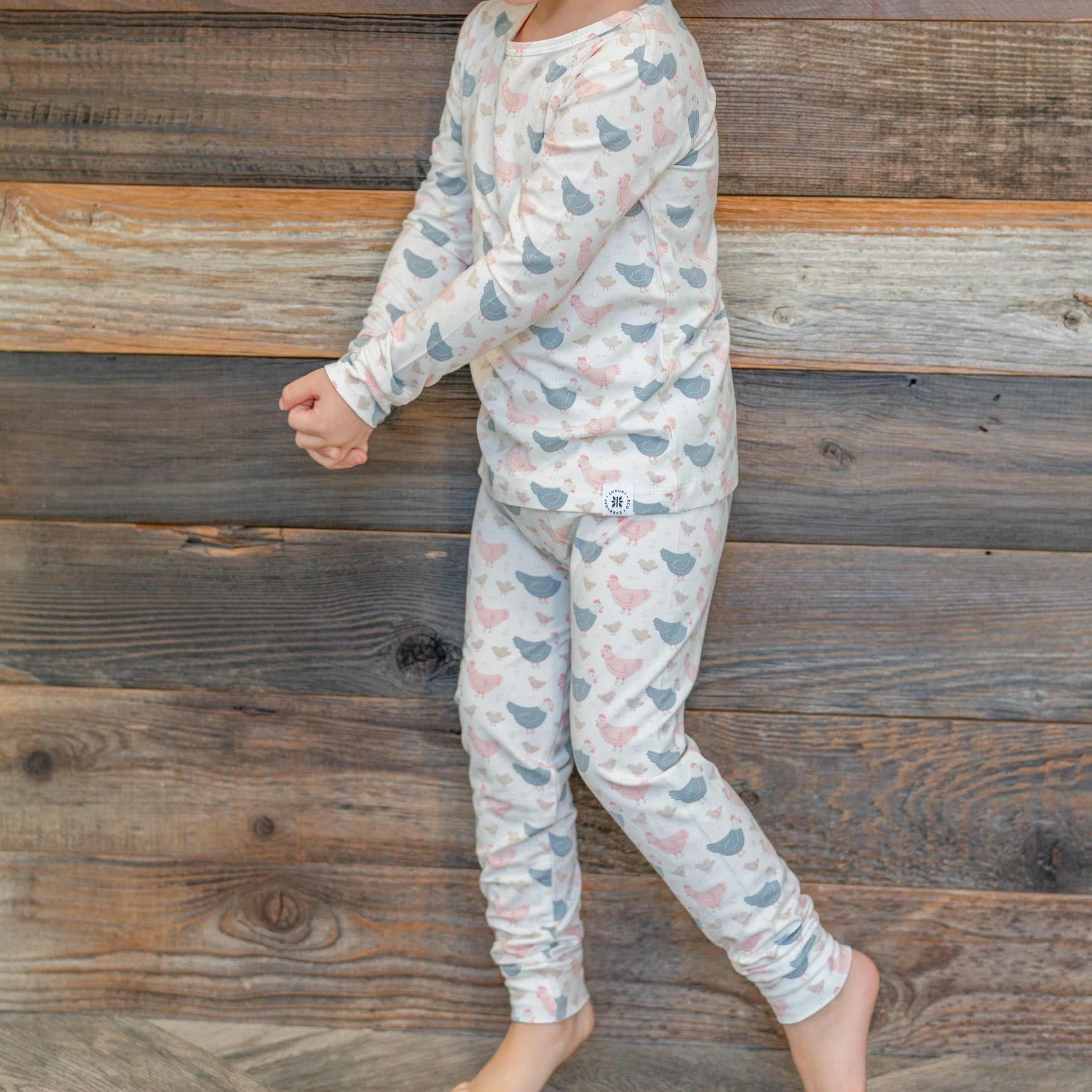 Kids bamboo pajama set with white base and blue/pink farm hen print, long sleeves and pants