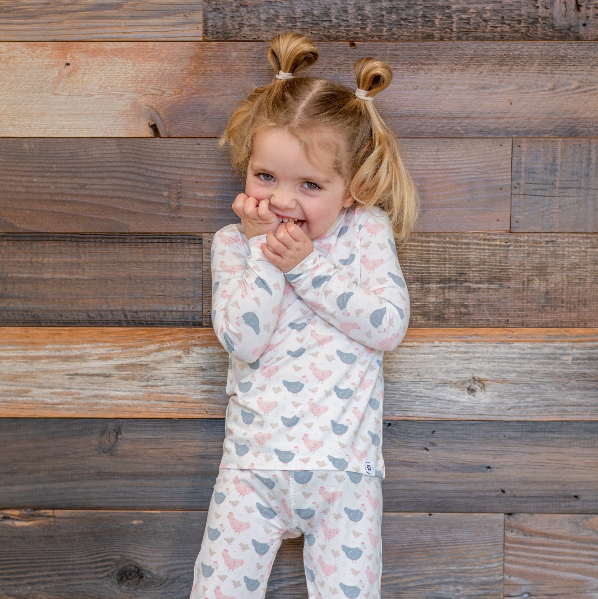 Kids bamboo pajama set with white base and blue/pink farm hen print, long sleeves