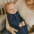 Knotted baby gown in dark blue with long sleeves and button placket
