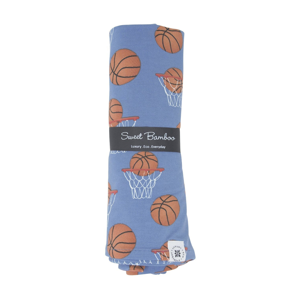 Blue swaddle blanket with basketball and hoop print, Sweet Bamboo label on fold.