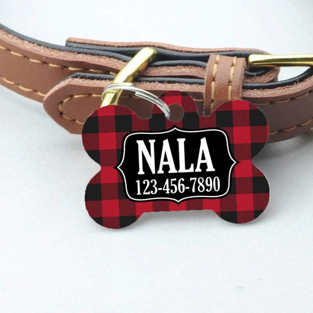 Red plaid bone-shaped dog ID tag with NALA and phone number on leather collar