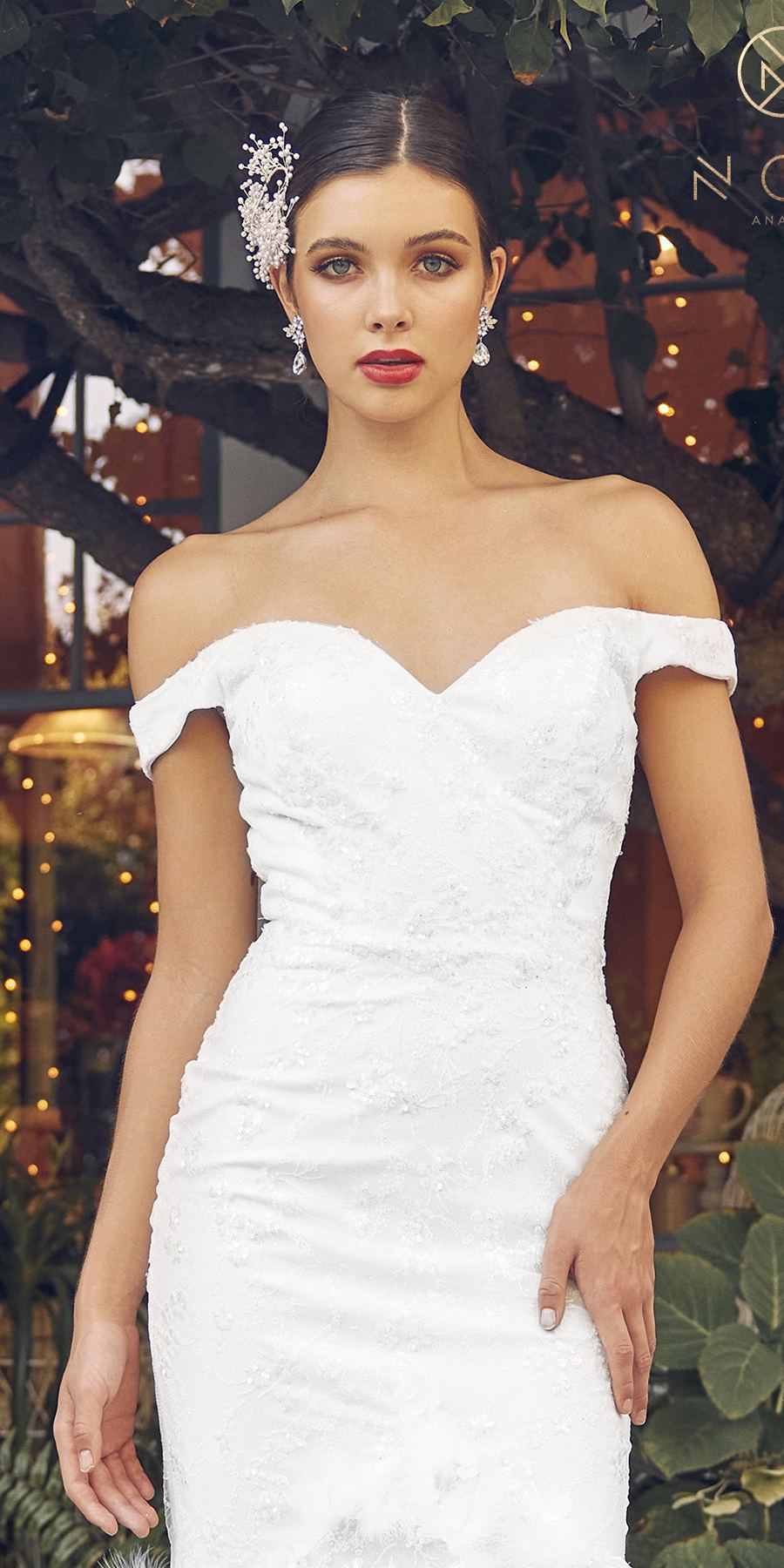 White off-shoulder fitted gown with structured bust and feathered trim