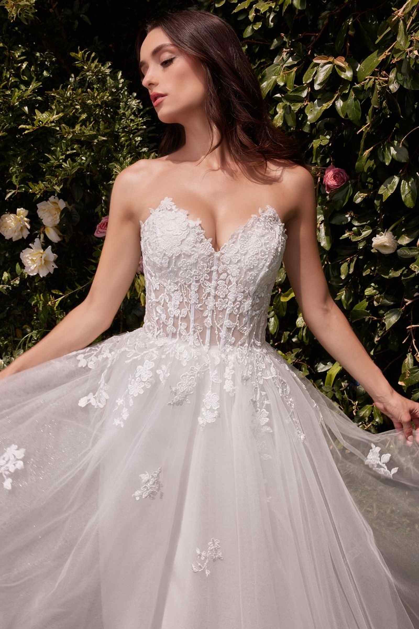 Off-white strapless wedding dress with ornate lace bodice and layered tulle skirt