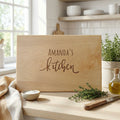 Personalized light wood cutting board with engraved “Amanda's Kitchen” text