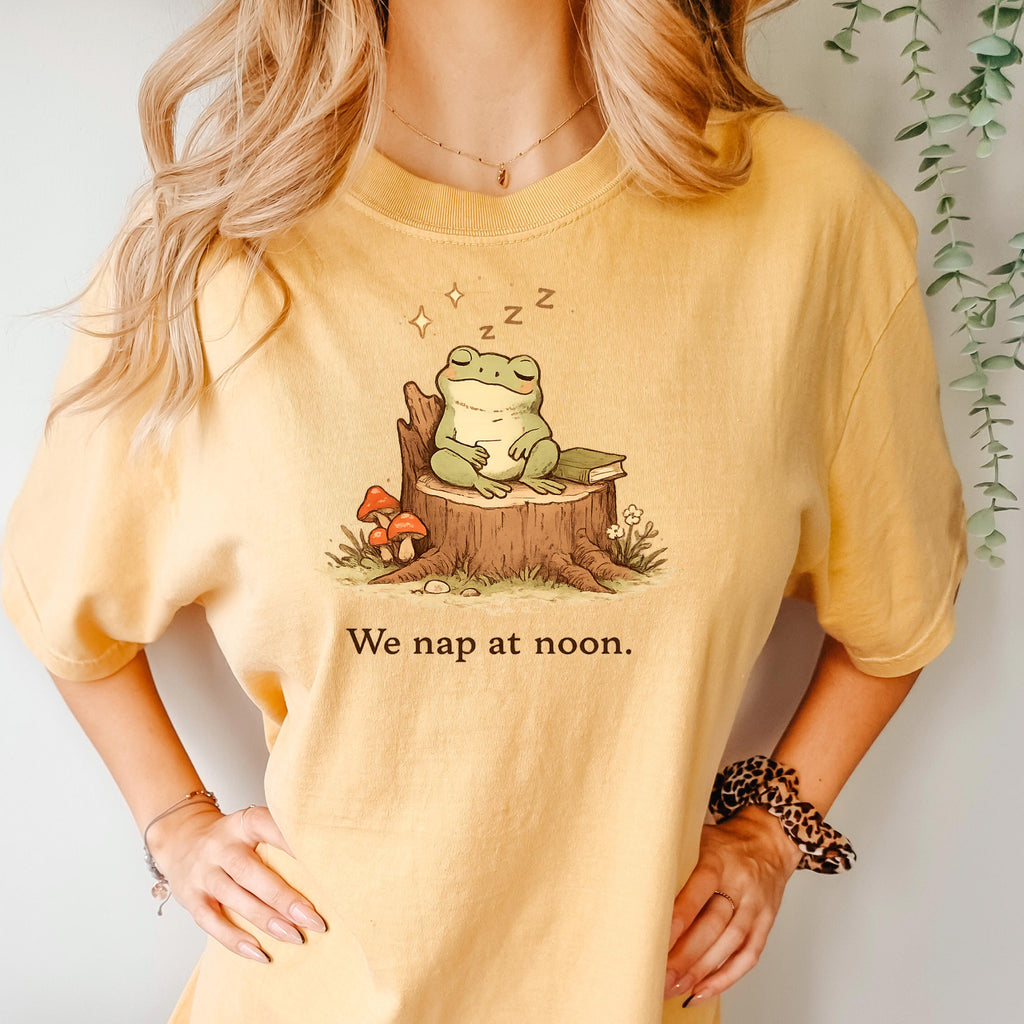Mustard/gold T-shirt with sleeping frog graphic and “We nap at noon.” text.
