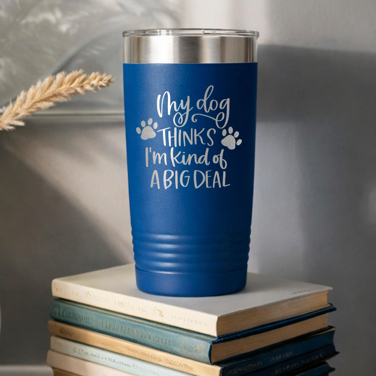 Blue stainless steel travel tumbler with dog paw quote: “My dog thinks I’m kind of a big deal”.