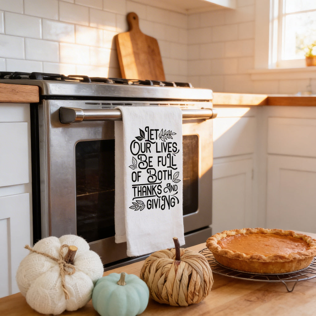 Thanksgiving kitchen towel with quote, hanging on stove front, white with black lettering