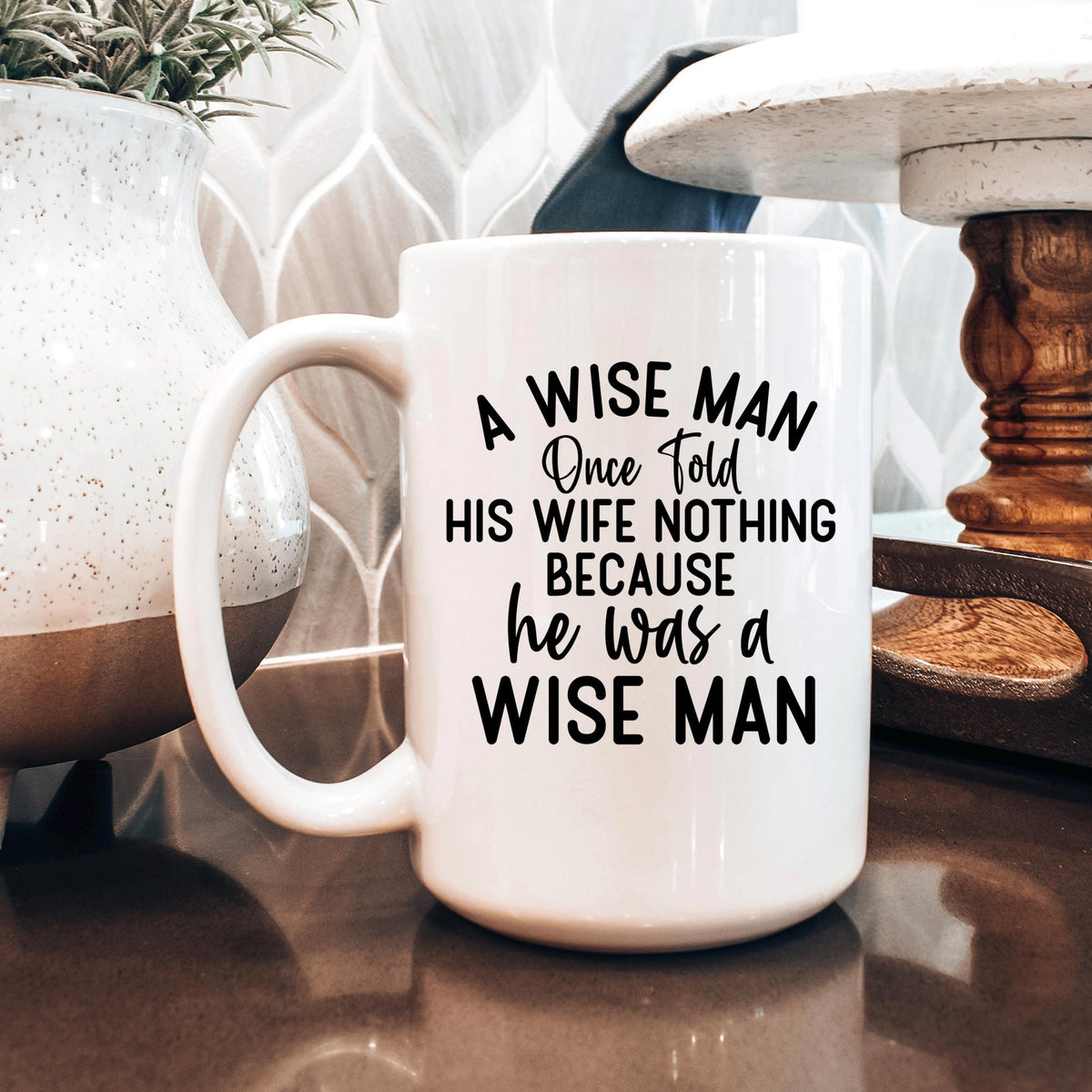White ceramic coffee mug with "A WISE MAN" quote in black and cursive