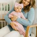 Pink knotted baby gown with long sleeves and front snaps, knot at waist