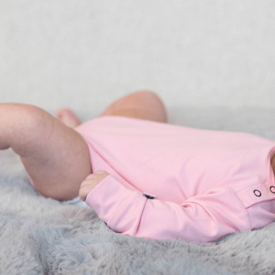 Candy pink long-sleeve bodysuit with snap button placket, stretch knit