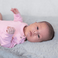Candy pink long-sleeve bodysuit with snap buttons at shoulder and neckline