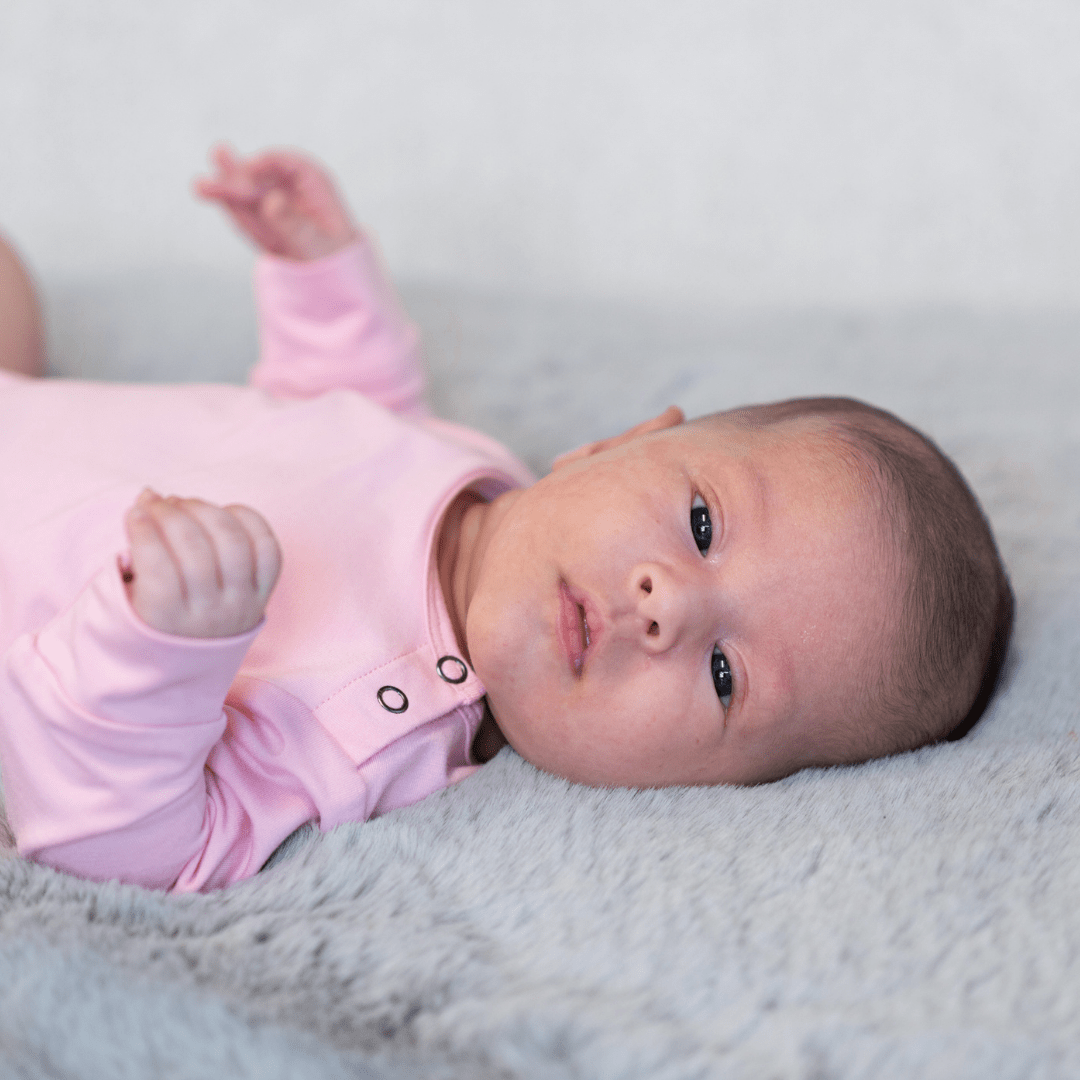 Candy pink long-sleeve bodysuit with snap buttons at shoulder and neckline