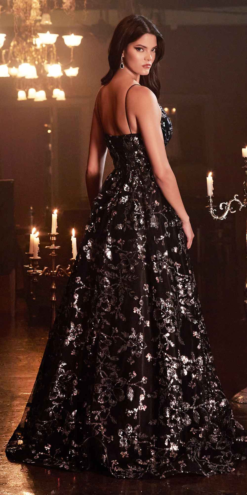 Black sequin ball gown with floral sparkle pattern, open-back straps, full floor-length skirt