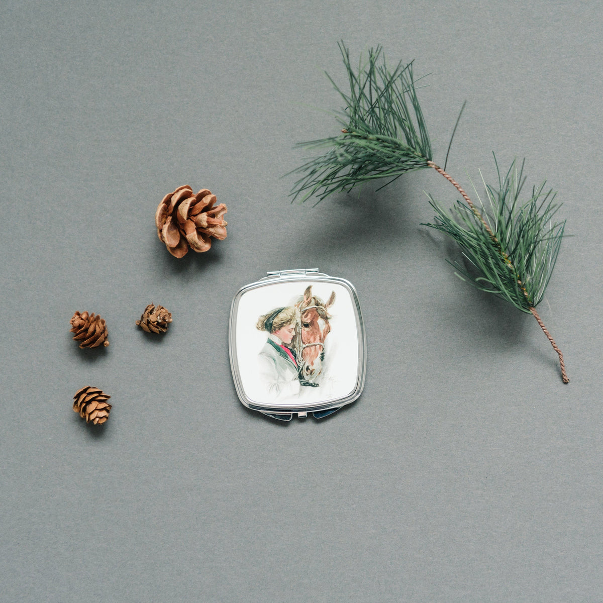 Square silver compact mirror with vintage horse portrait illustration on the lid