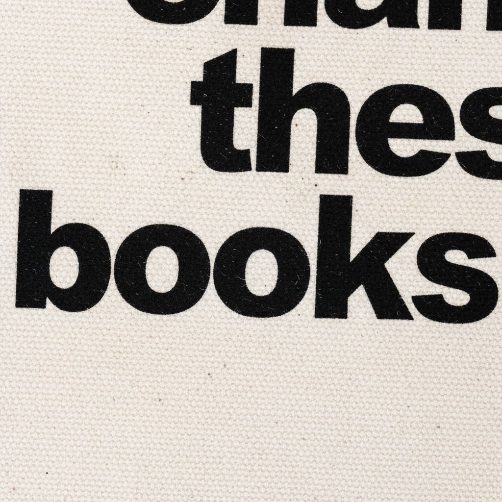 Close-up of cream canvas tote bag with bold black text: books are overdue