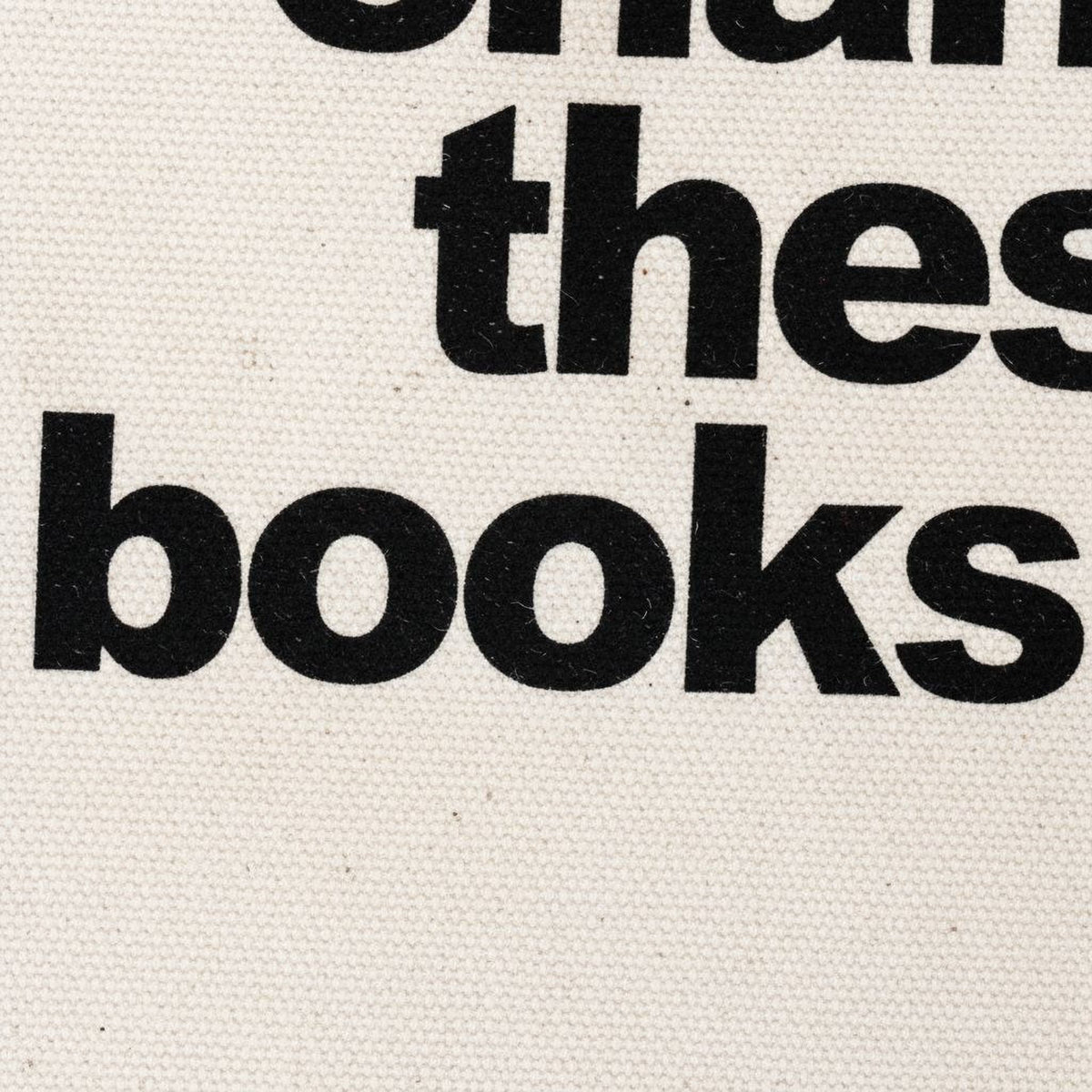 Close-up of cream canvas tote bag with bold black text: books are overdue