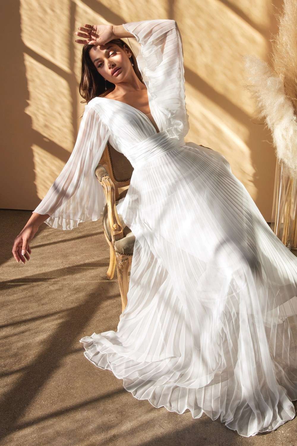 Off-white chiffon long sleeve gown with airy pleated skirt and V-neck front