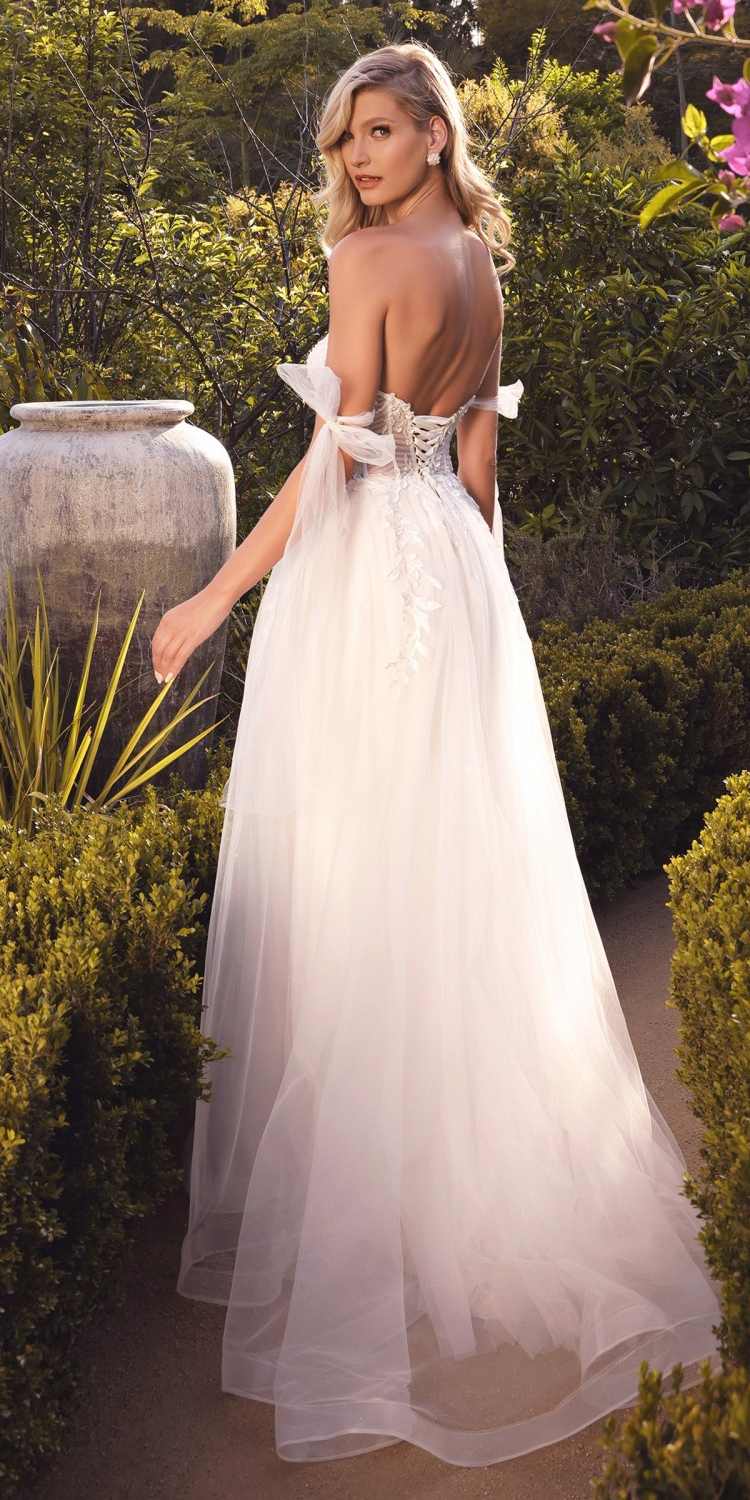 Off-white A-line wedding gown with lace corset bodice, ribbon shoulder ties, and sheer skirt