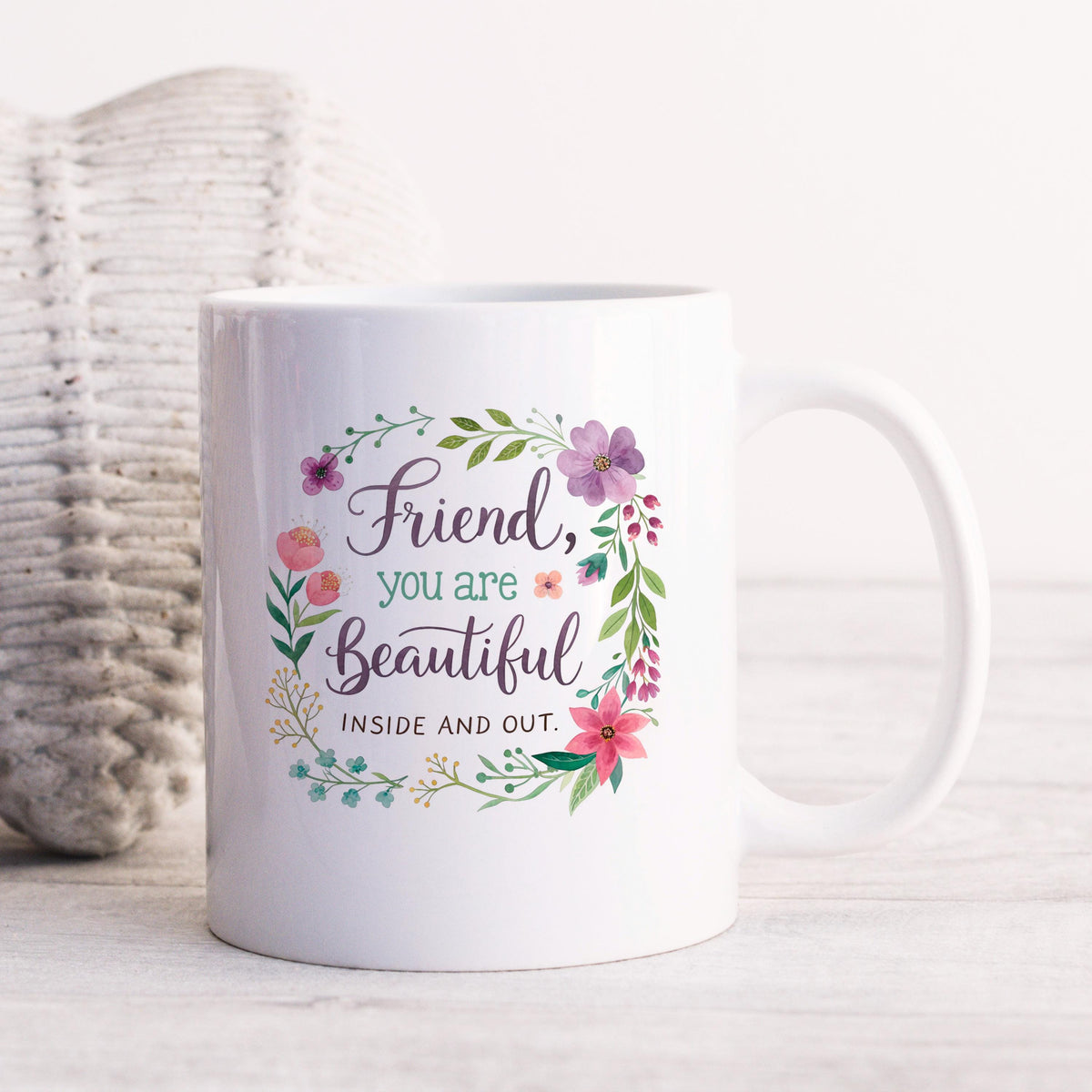 White coffee mug with floral wreath graphic and “Friend, you are Beautiful” text