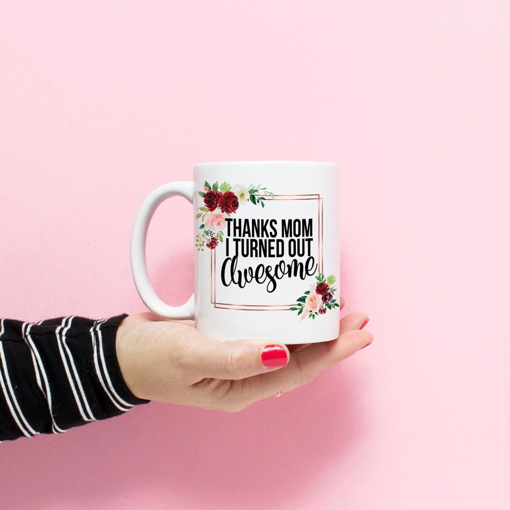 White coffee mug with floral frame and text 'Thanks mom I turned out awesome'
