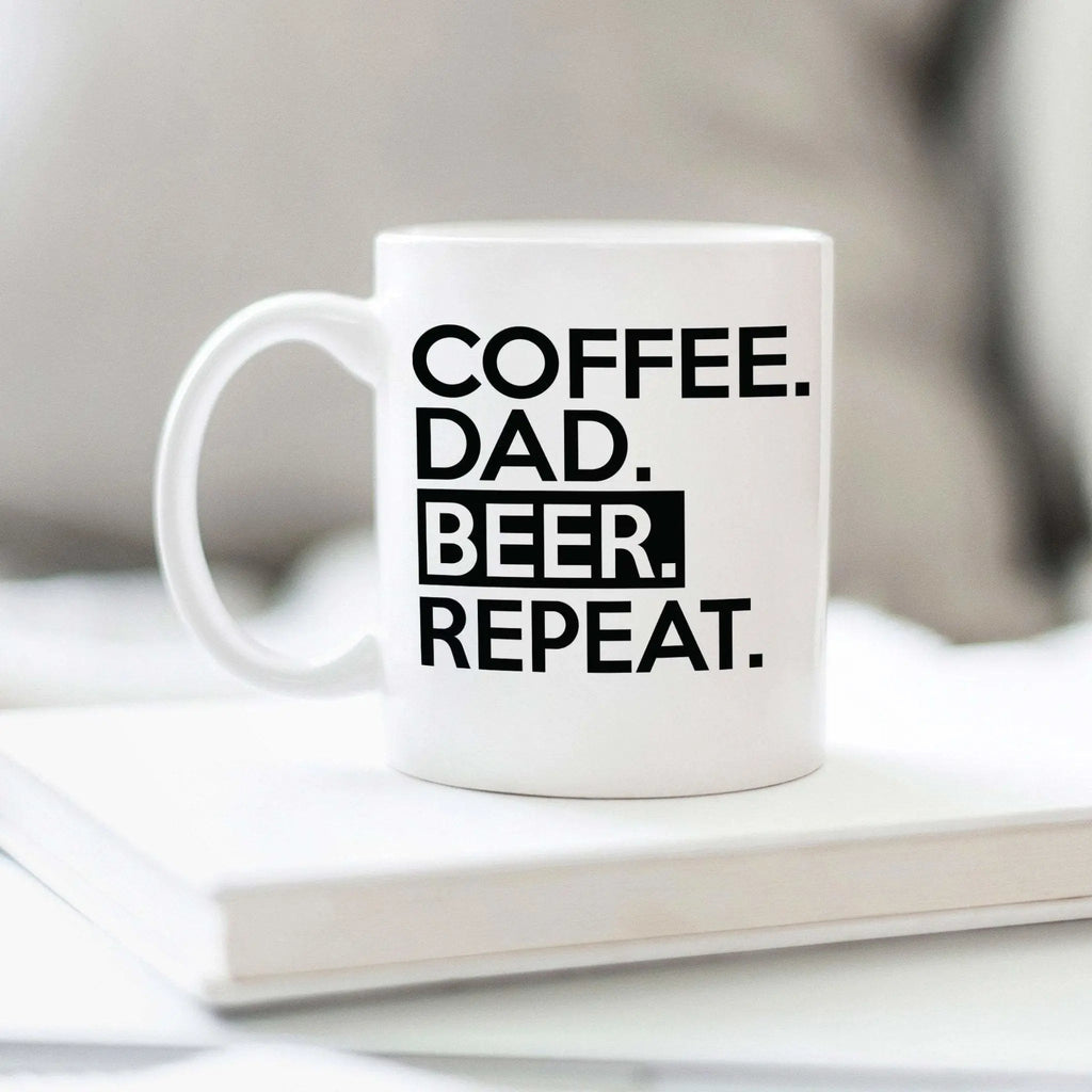 White ceramic coffee mug with COFFEE DAD BEER REPEAT text, handle on left
