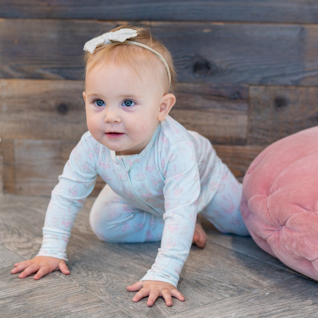 Light blue swan-print long-sleeve baby romper with front snaps, footed legs