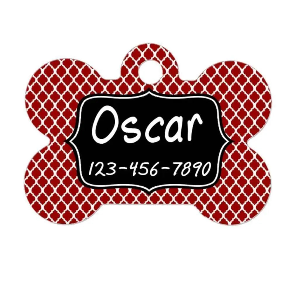 Bone-shaped pet ID tag with red quatrefoil pattern and black name plate, hole for ring