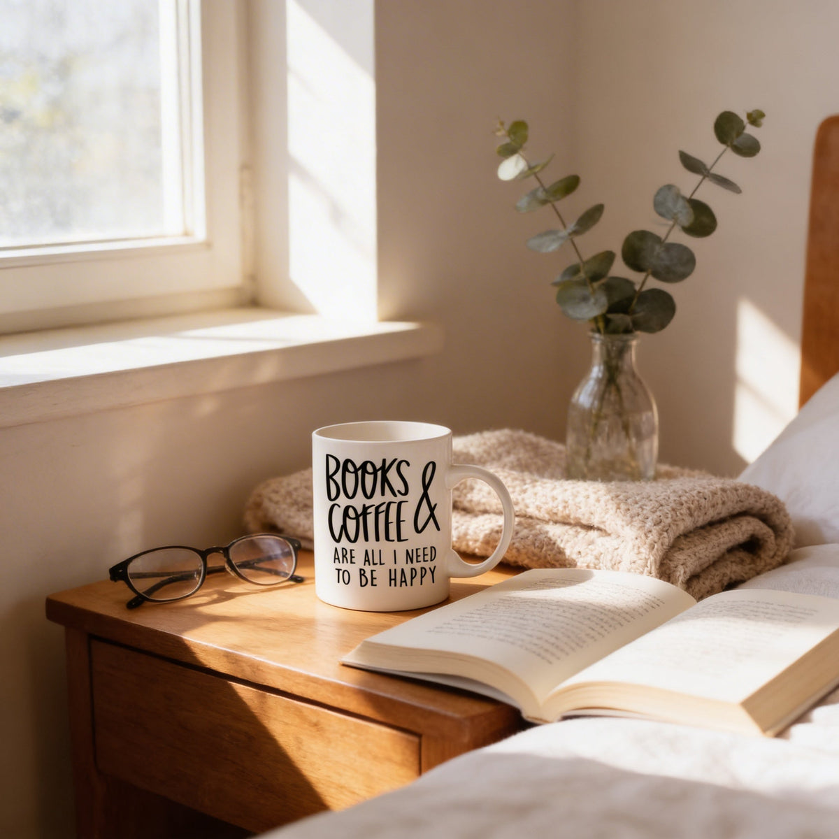 White ceramic mug with 'BOOKS & COFFEE' quote beside an open book