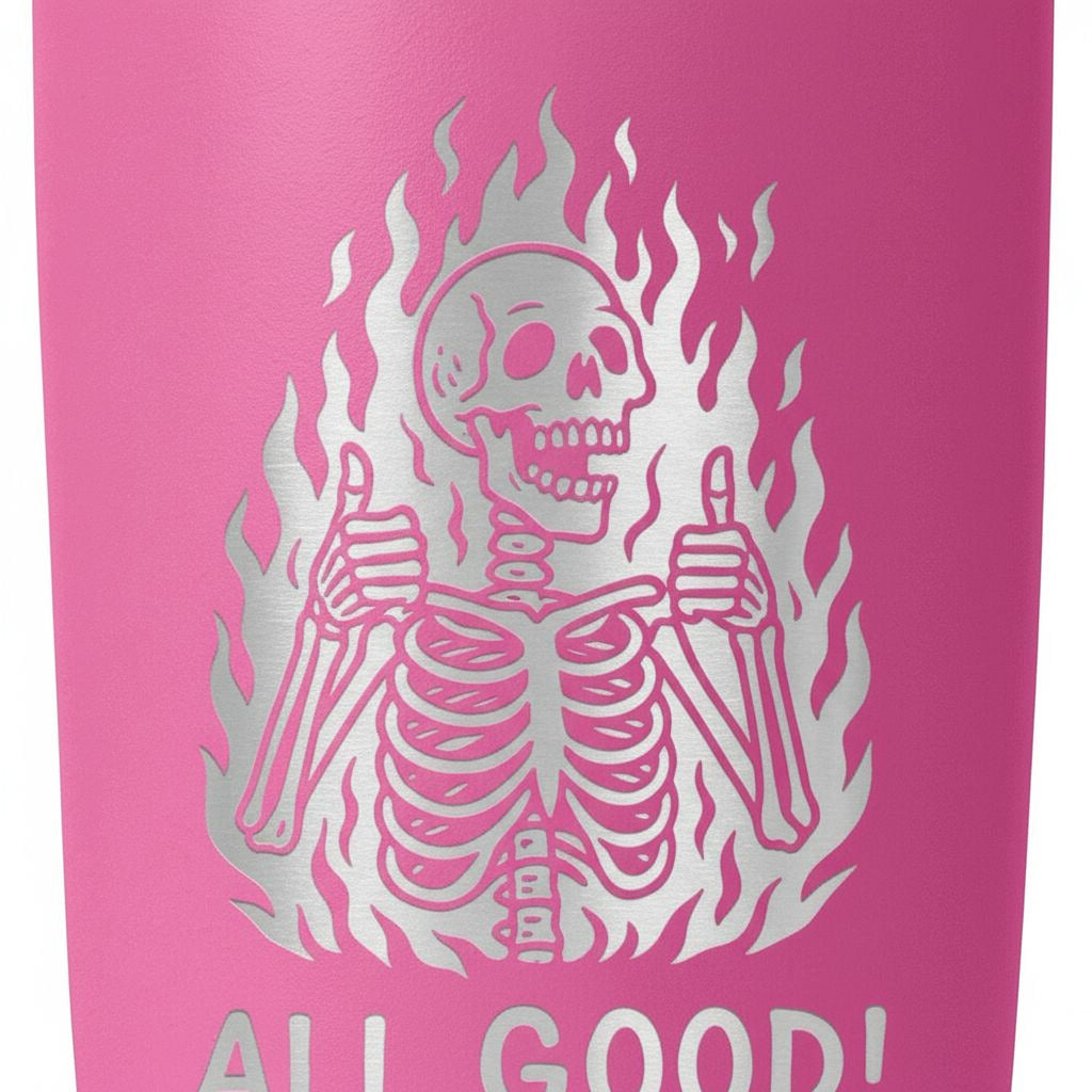 Pink insulated tumbler close-up with white flaming skeleton and “ALL GOOD!” text