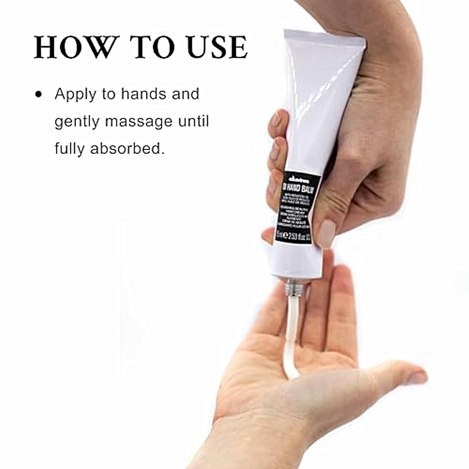 Davines OI Hand Balm squeeze tube held in hand with black cap at bottom