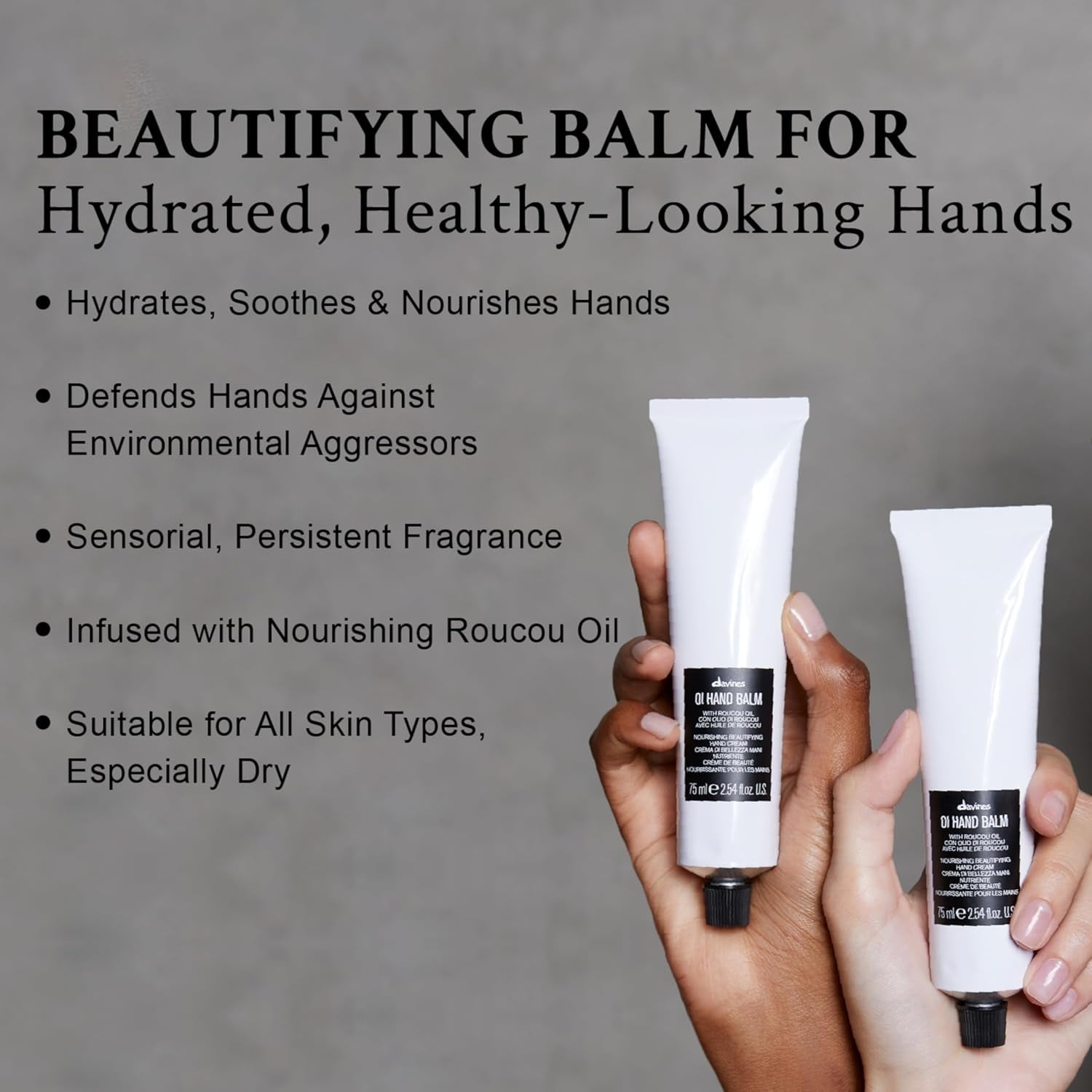 Davines OI Hand Balm two squeeze tubes held by hands, black caps visible