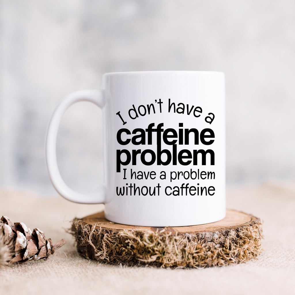 White ceramic mug on a coaster with "I don't have a caffeine problem" quote