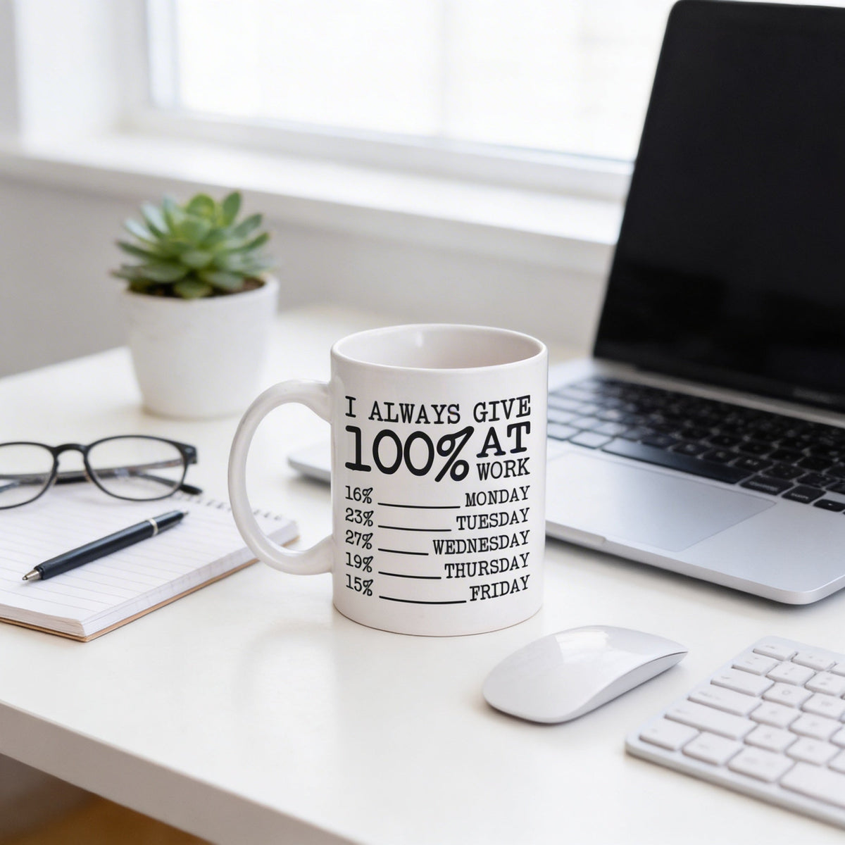 White ceramic coffee mug on desk with black "I always give 100% at work" design