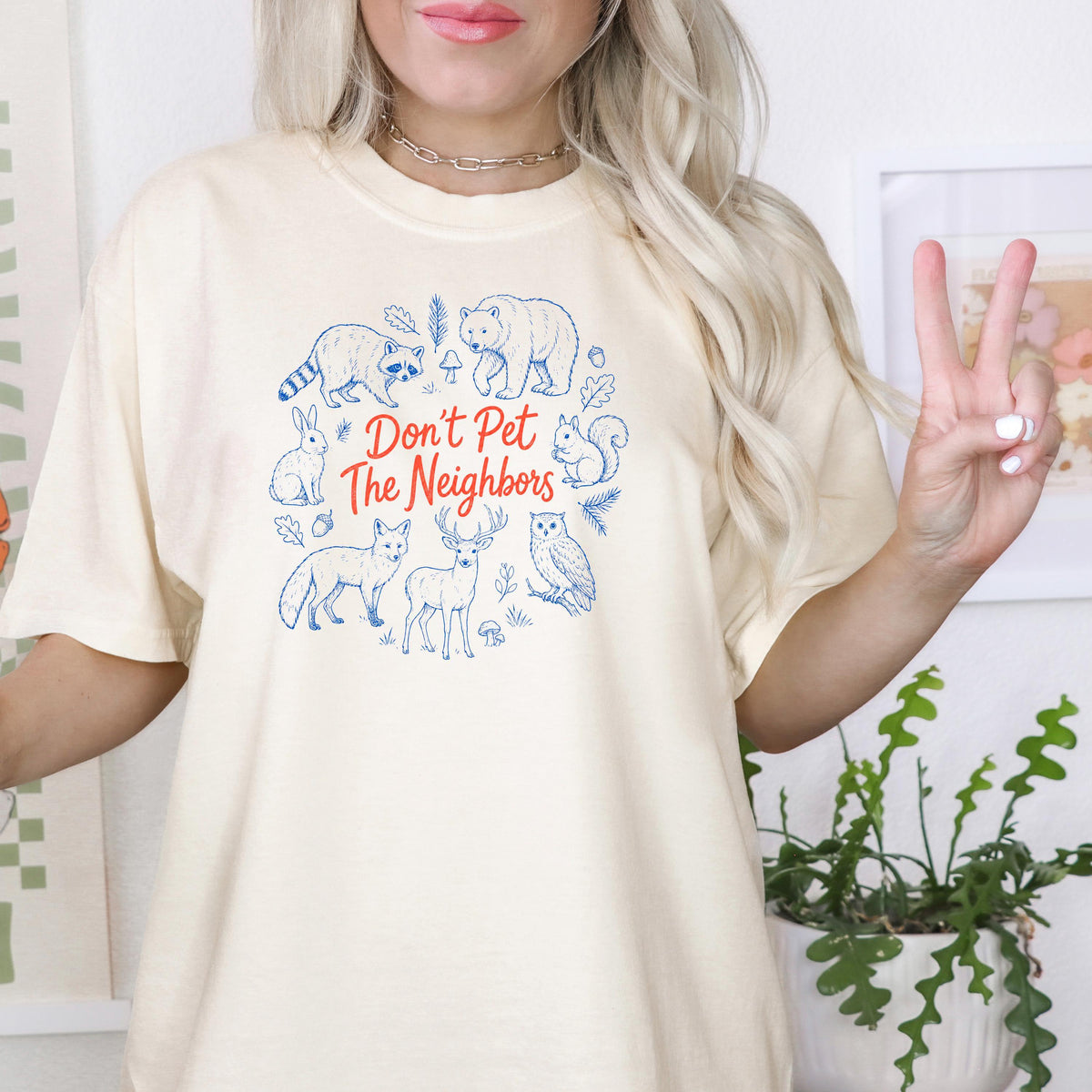 Ivory crewneck T-shirt with blue woodland animals and red 'Don't Pet The Neighbors' graphic