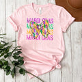 Pink short-sleeve t-shirt with Mardi Gras bow and colorful stacked text graphic