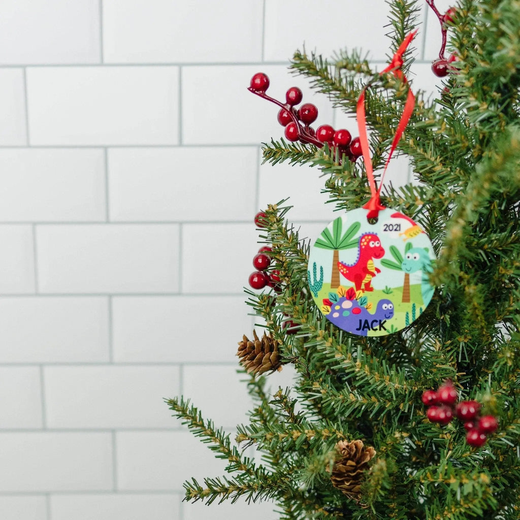Dinosaur ornament on Christmas tree with red ribbon, '2021' and 'JACK' visible