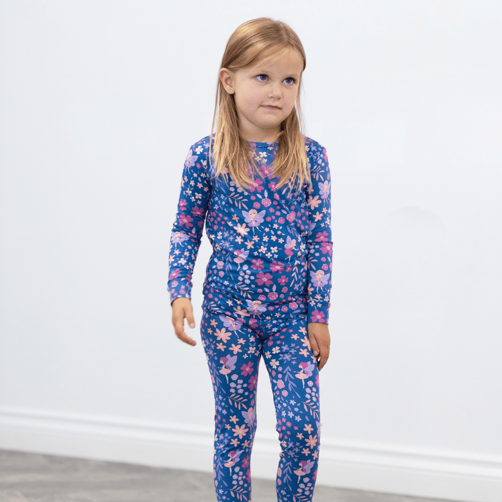 Girls kids pajama set on model: blue floral long-sleeve top with matching pants