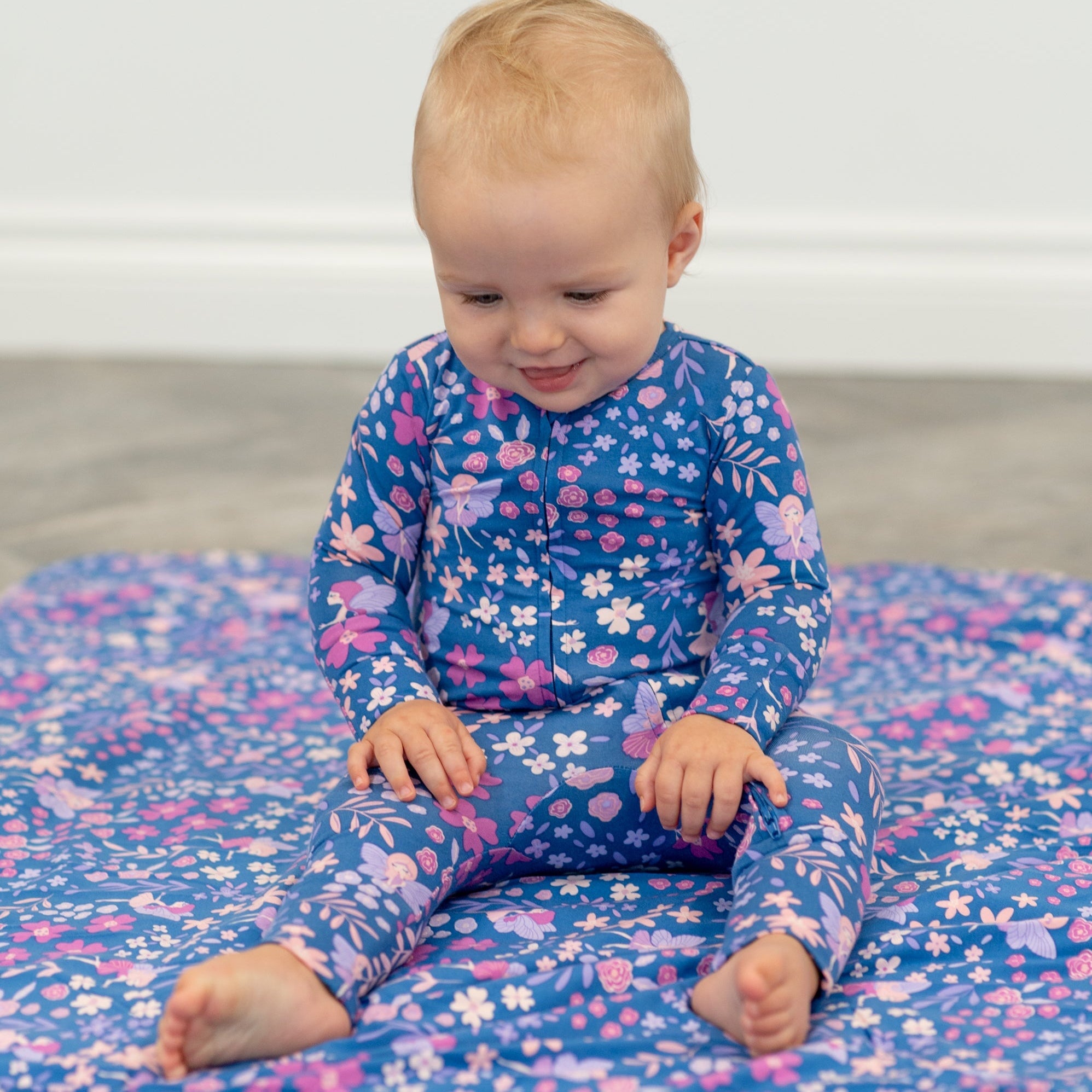 Blue floral long-sleeve romper with full-length legs, round neck, and cuffs