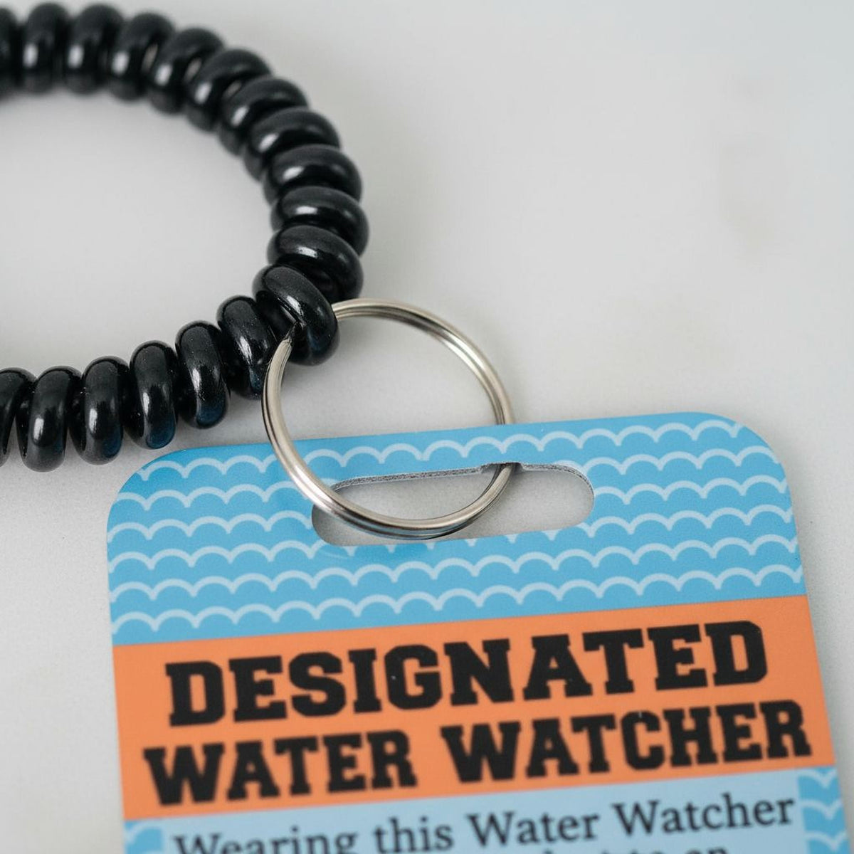 Blue water watcher badge card with black beaded lanyard and metal key ring