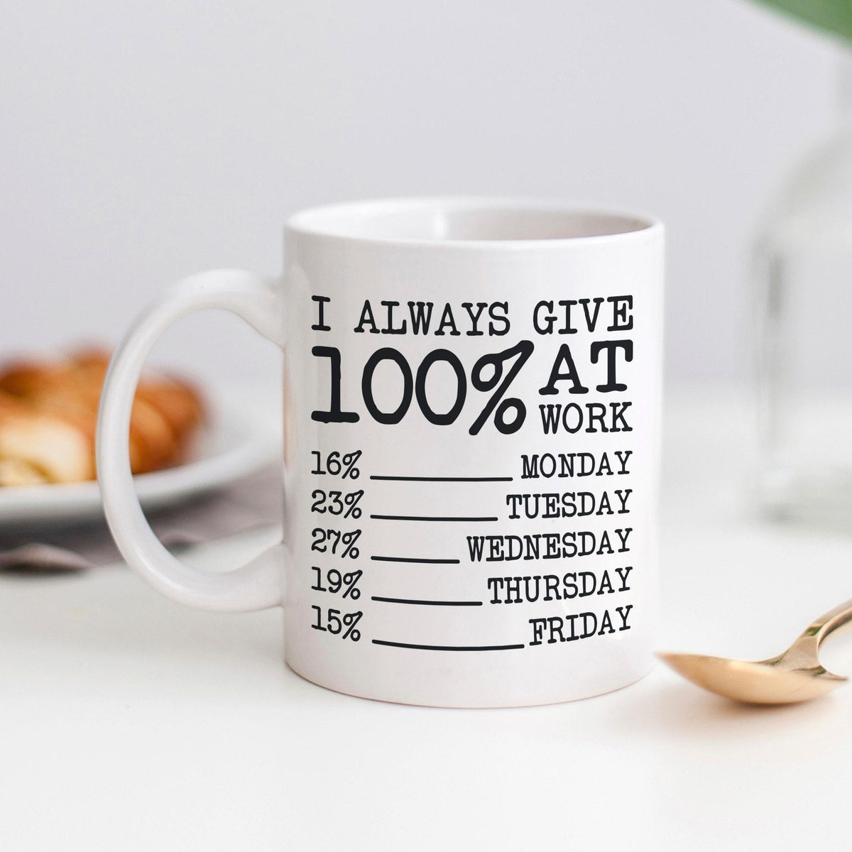 White ceramic coffee mug with black "I always give 100% at work" text