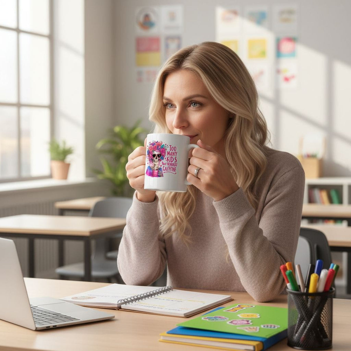 White ceramic mug held in front of a person, featuring floral crown skull and “Too Many Kids” quote.