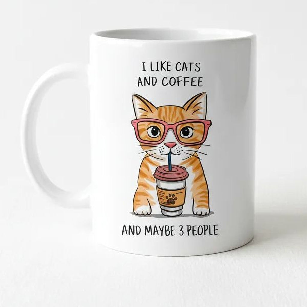 White ceramic mug with orange tabby cat wearing glasses and holding a coffee cup