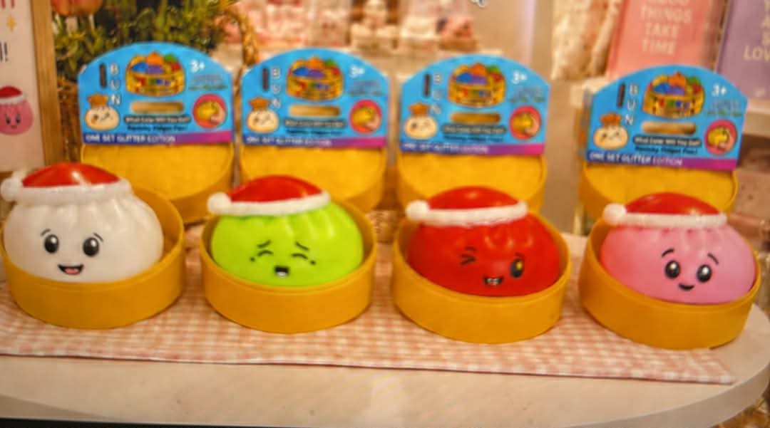 Set of four holiday dumpling toys with smiling faces in yellow bases