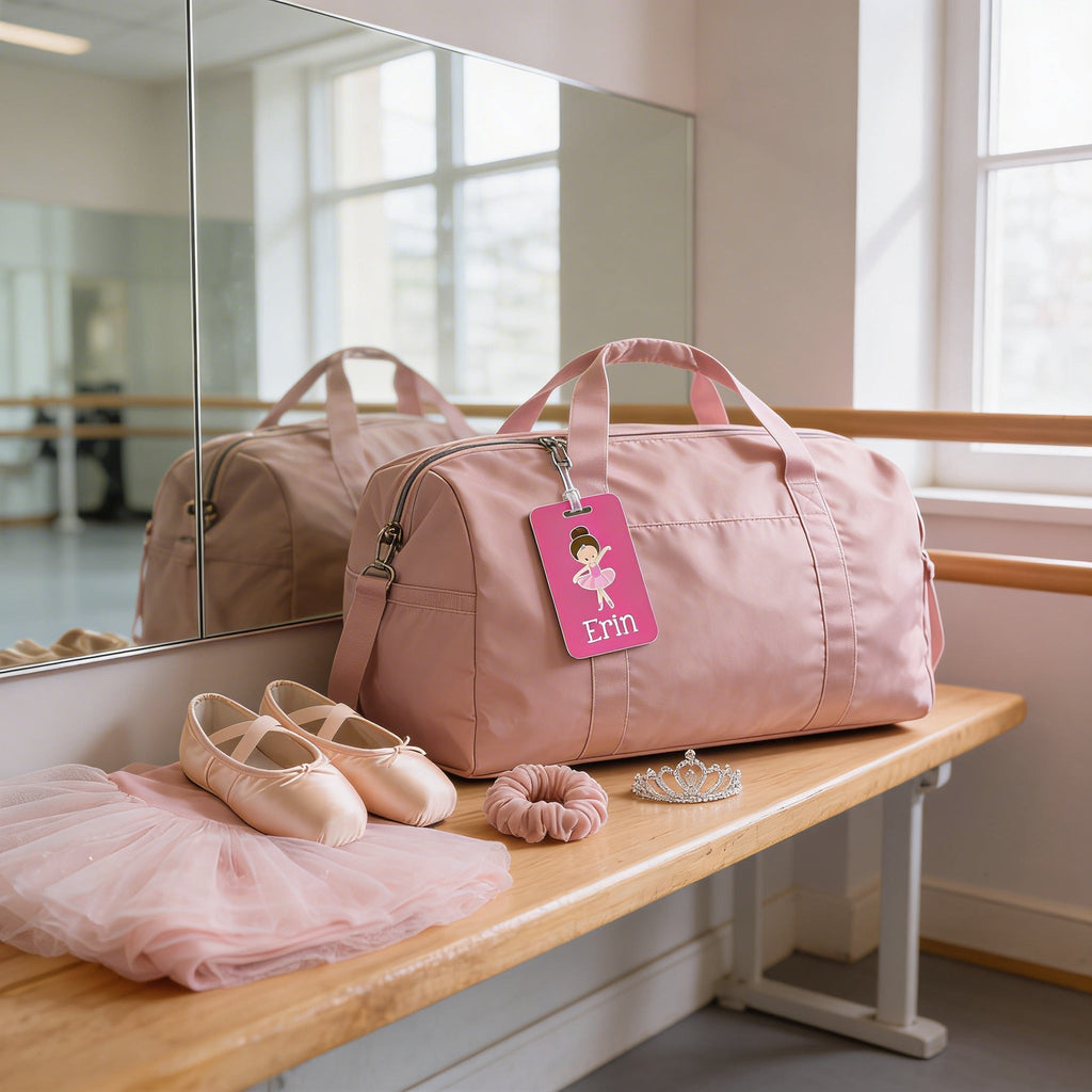 Ballet luggage tag with name Erin on a pink duffel bag near ballet shoes