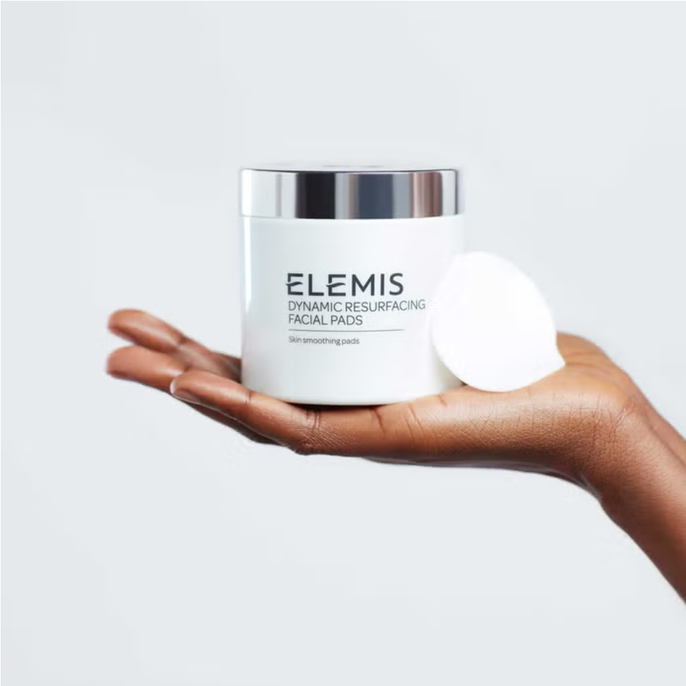 Elemis facial pads jar in a hand with a white round pad