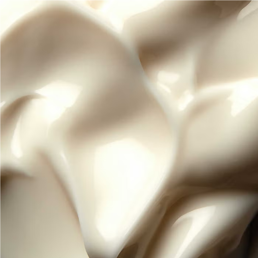Ultra-rich facial cream swirled in close-up, thick pale off-white texture